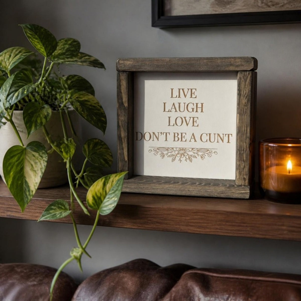 Live laugh love don't be a cunt framed sign on a shelf