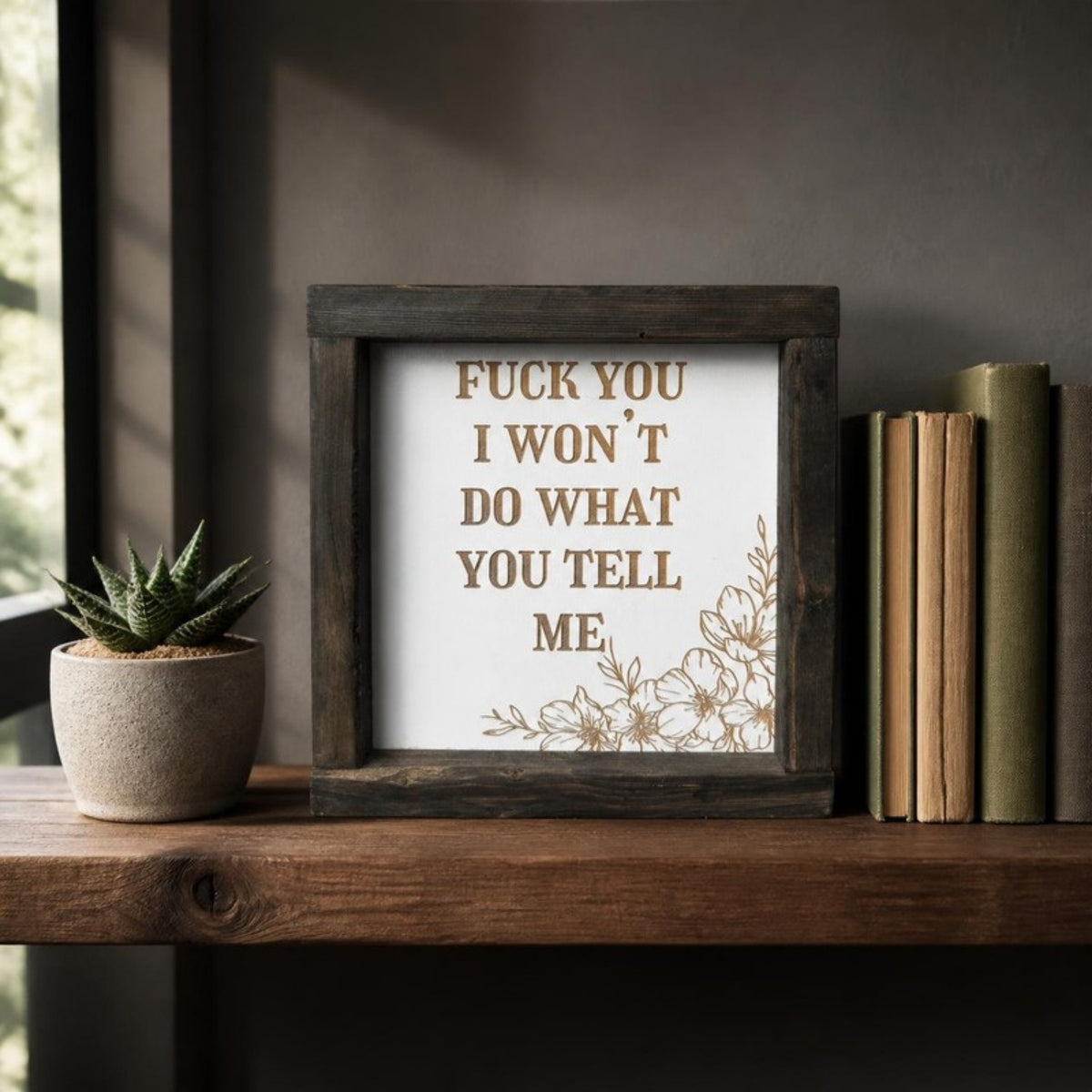 Fuck you I won't do what you tell me framed sign on a shelf